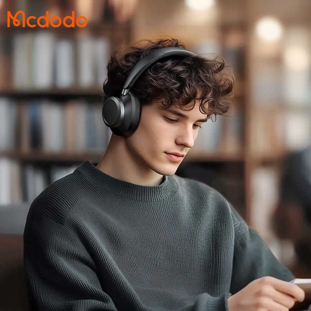 MCDODO HP-582 T03 superior active noise cancelling headphones در گوش یک پسر در کتابخانه